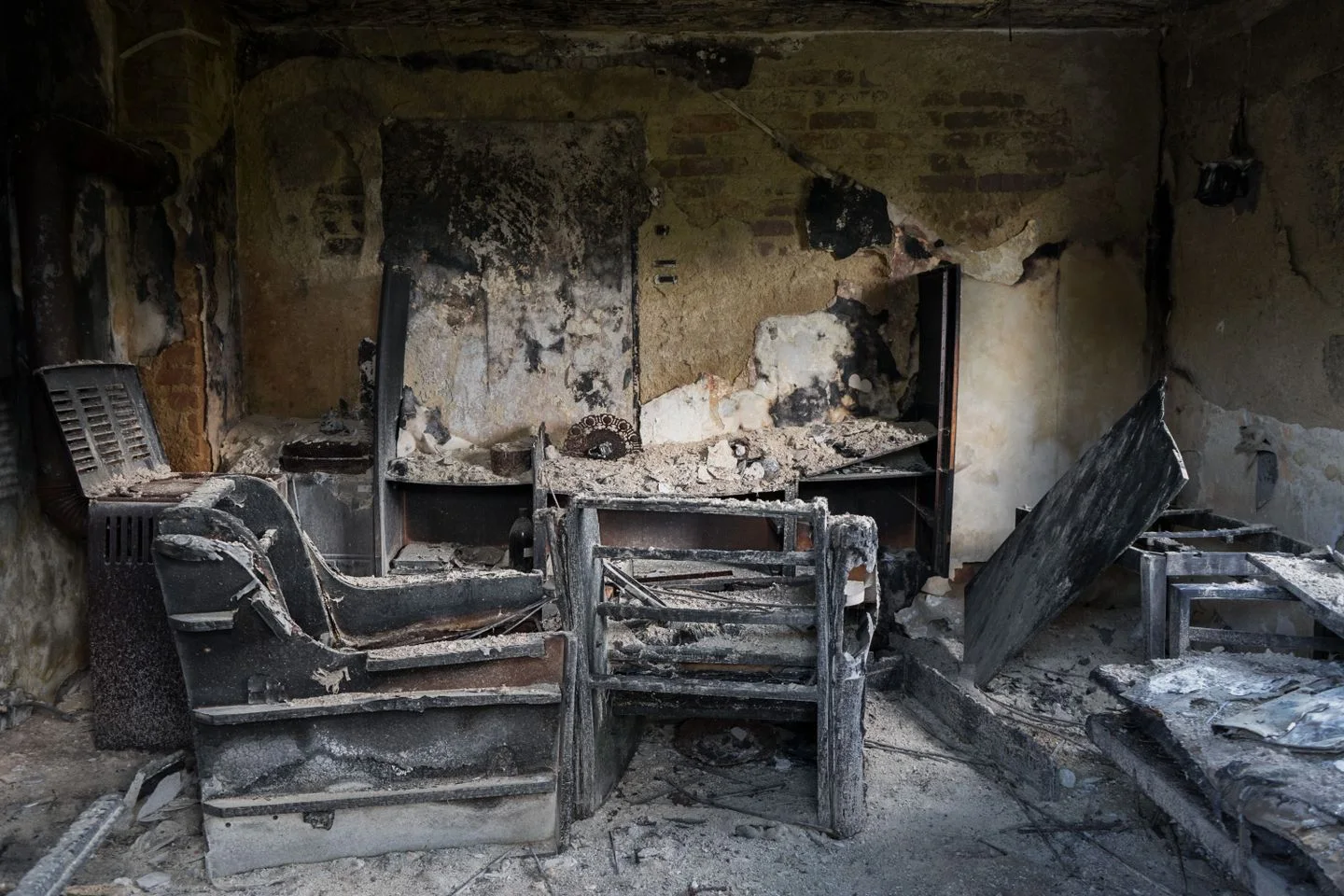 Dark interior containing charred household furniture