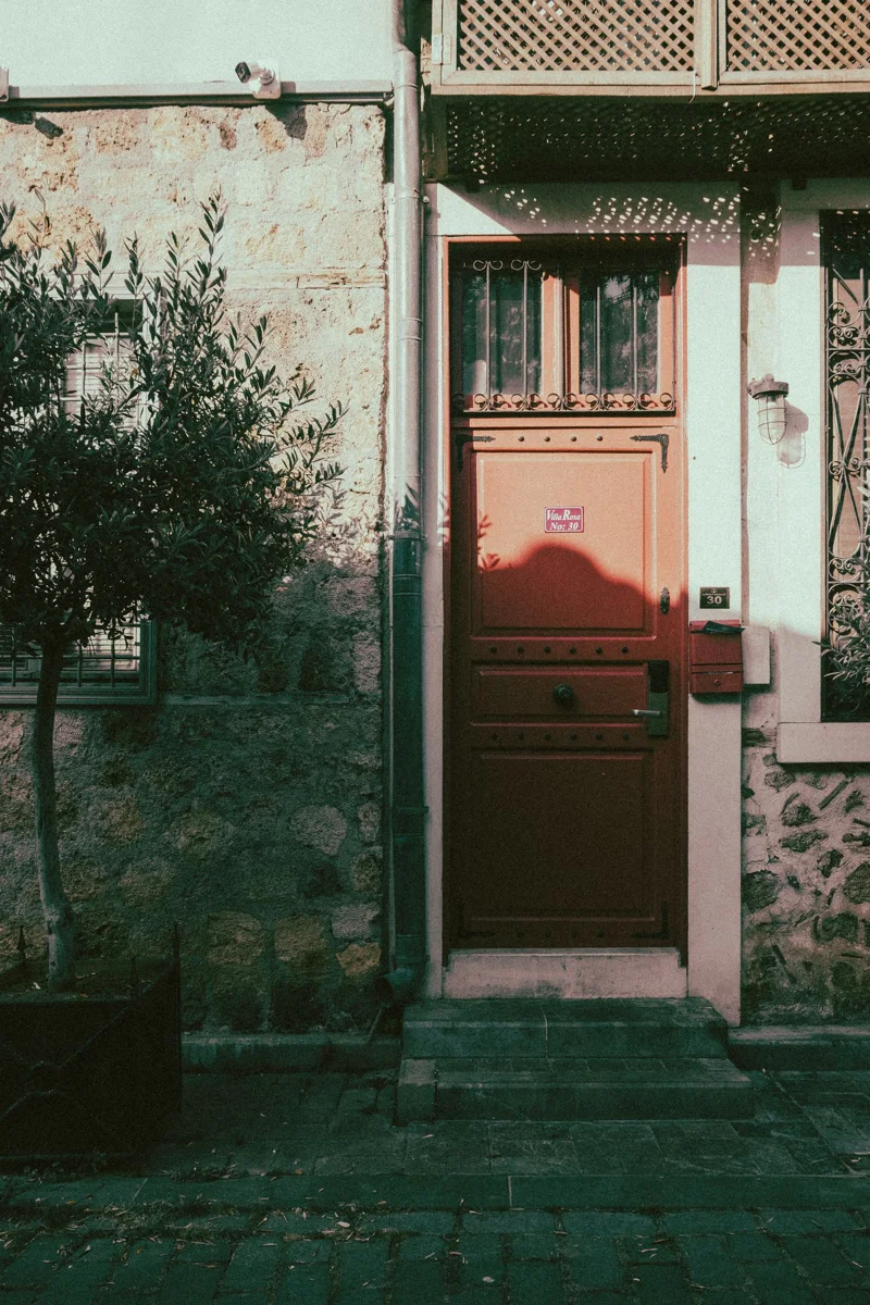 Closed red entrance door in a stone facade