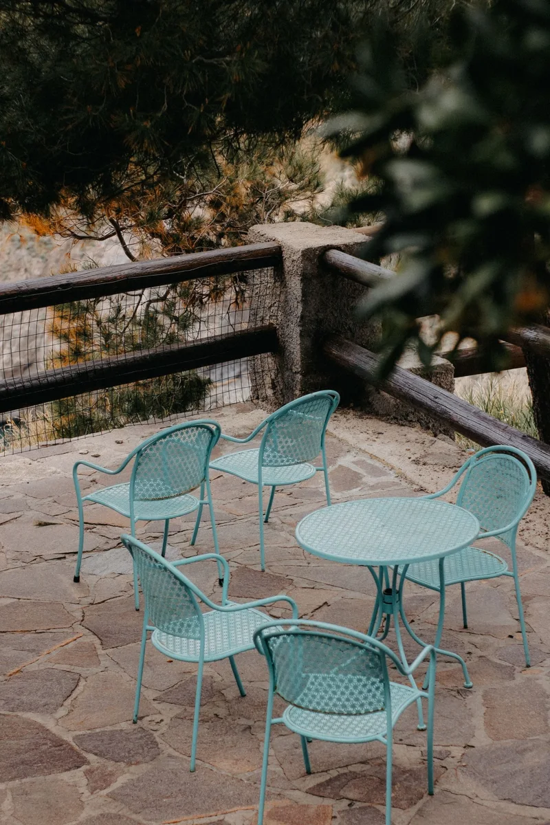 Outdoor chairs and a table on a stone patio.