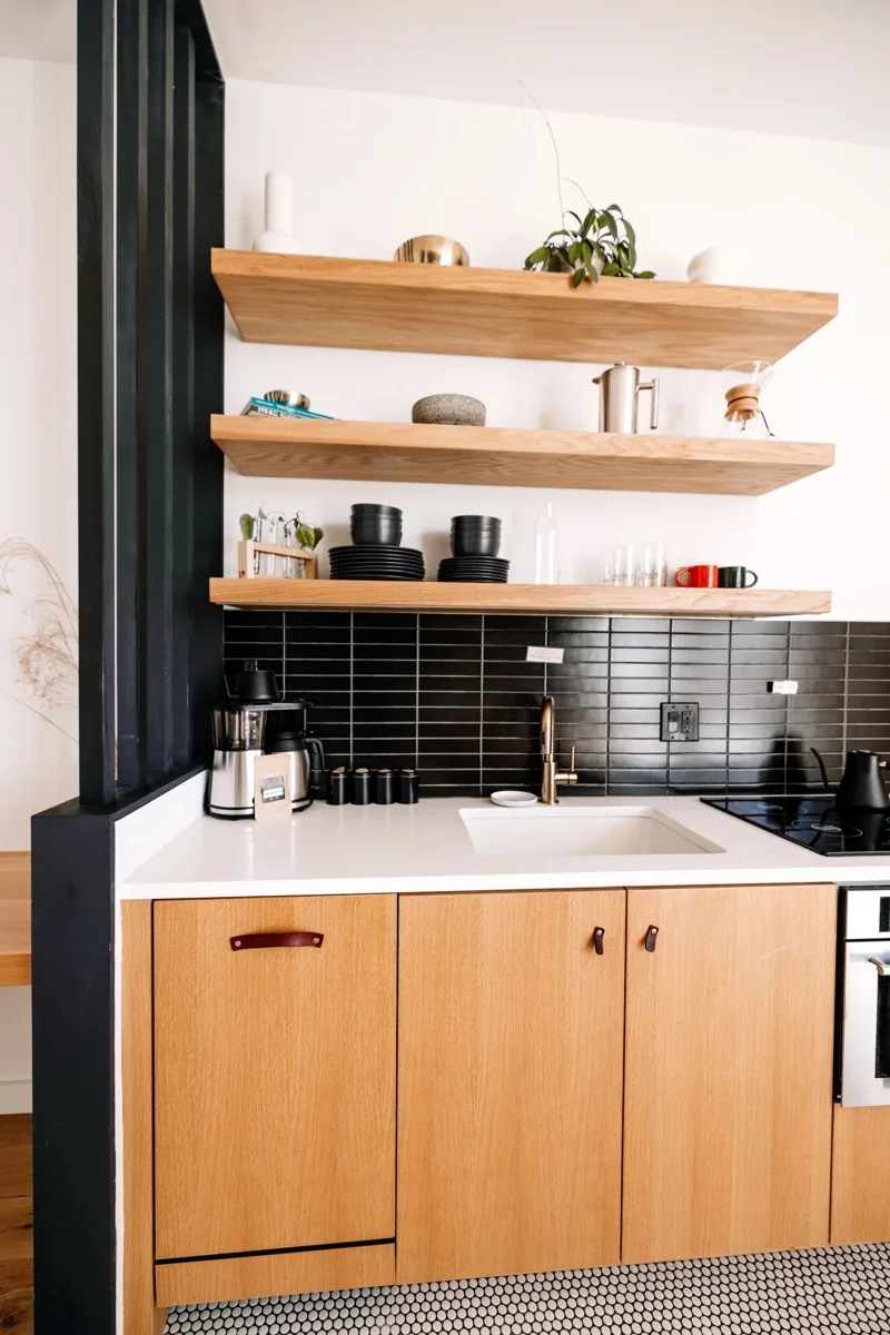 Wooden kitchen cabinets and fixed open shelves.