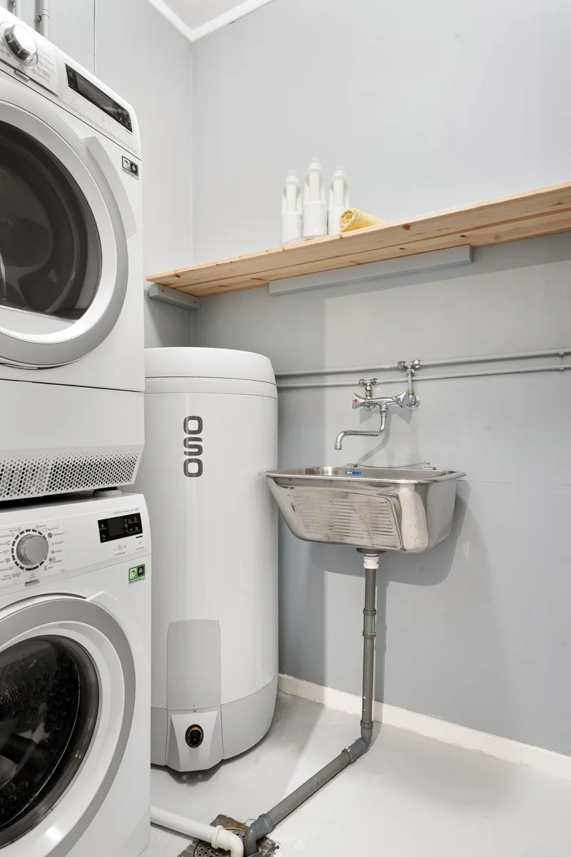 Washing machines beside a sink in a laundry room