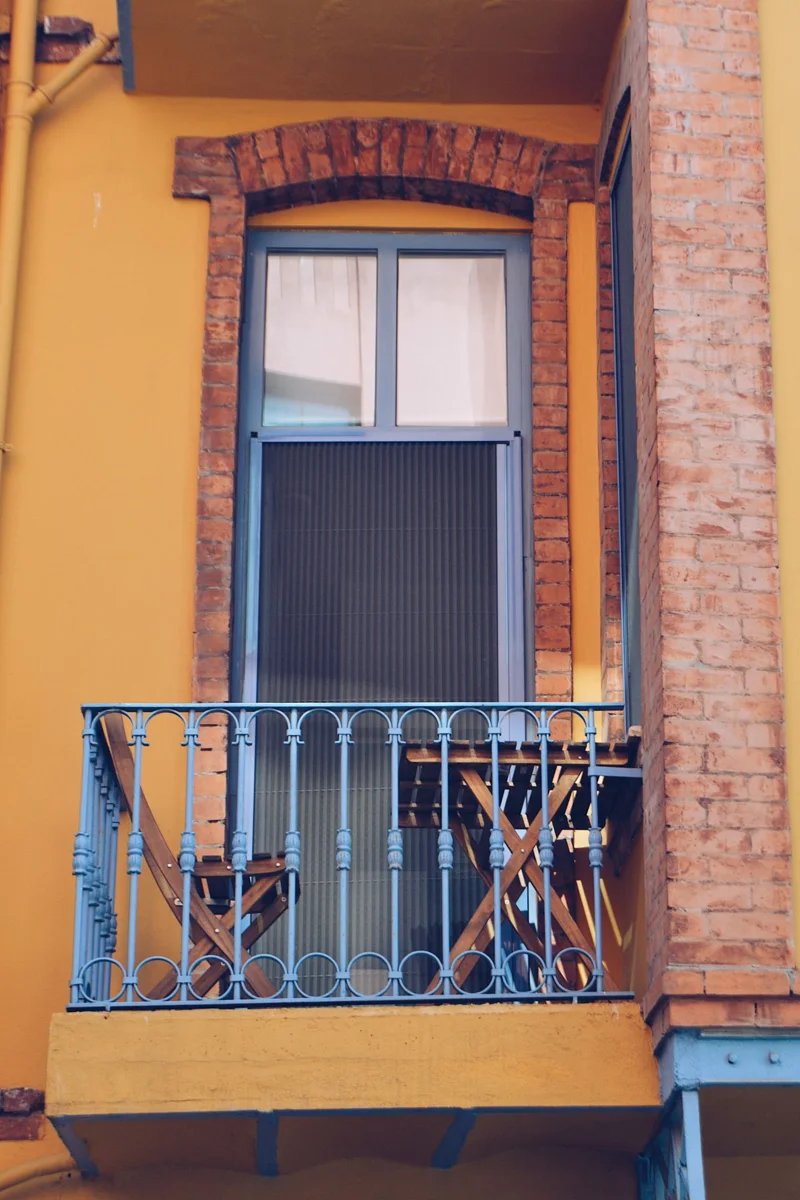 A balcony furnished with a table and chairs