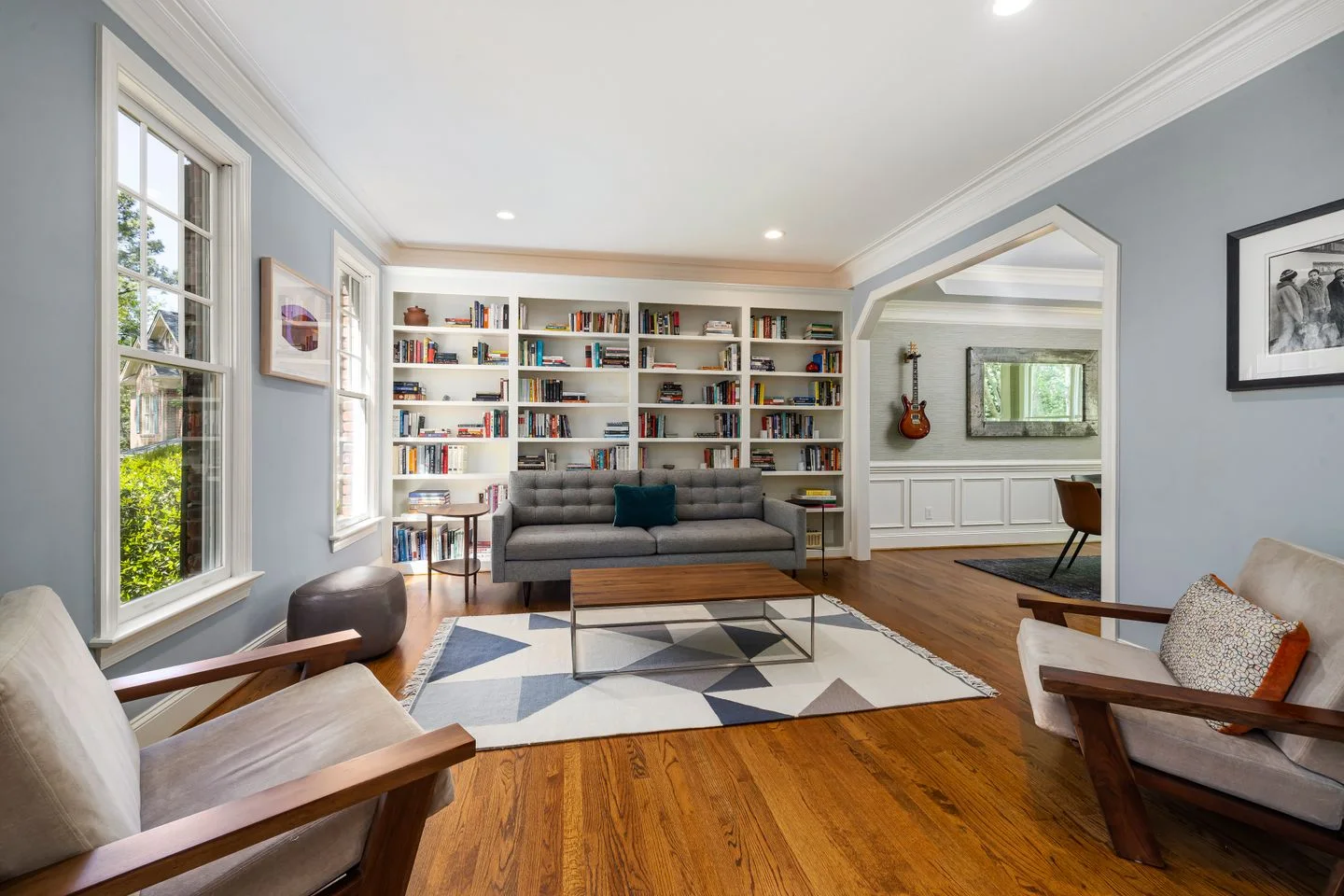 Living room with a sofa, armchairs, and a large bookcase