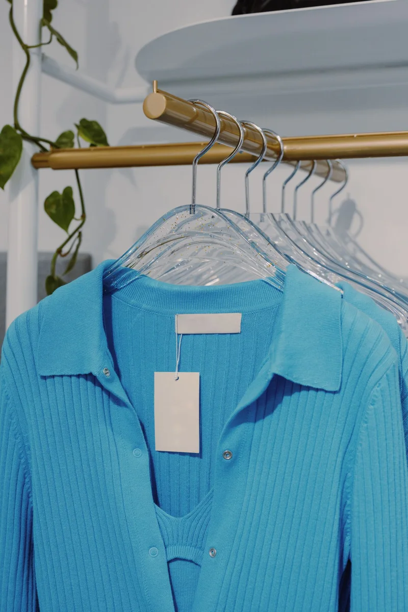 Blue garments hang side by side on a clothing rack