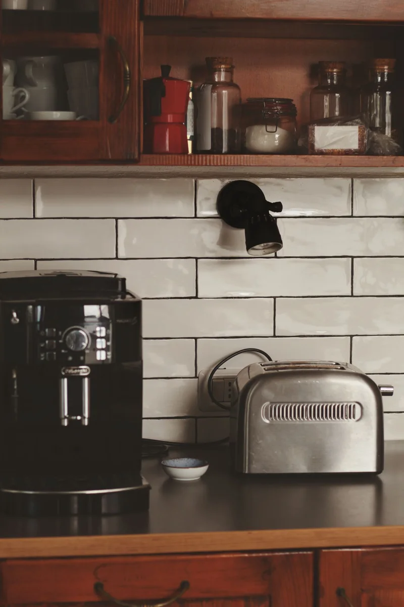 A coffee machine and toaster stand on a kitchen counter