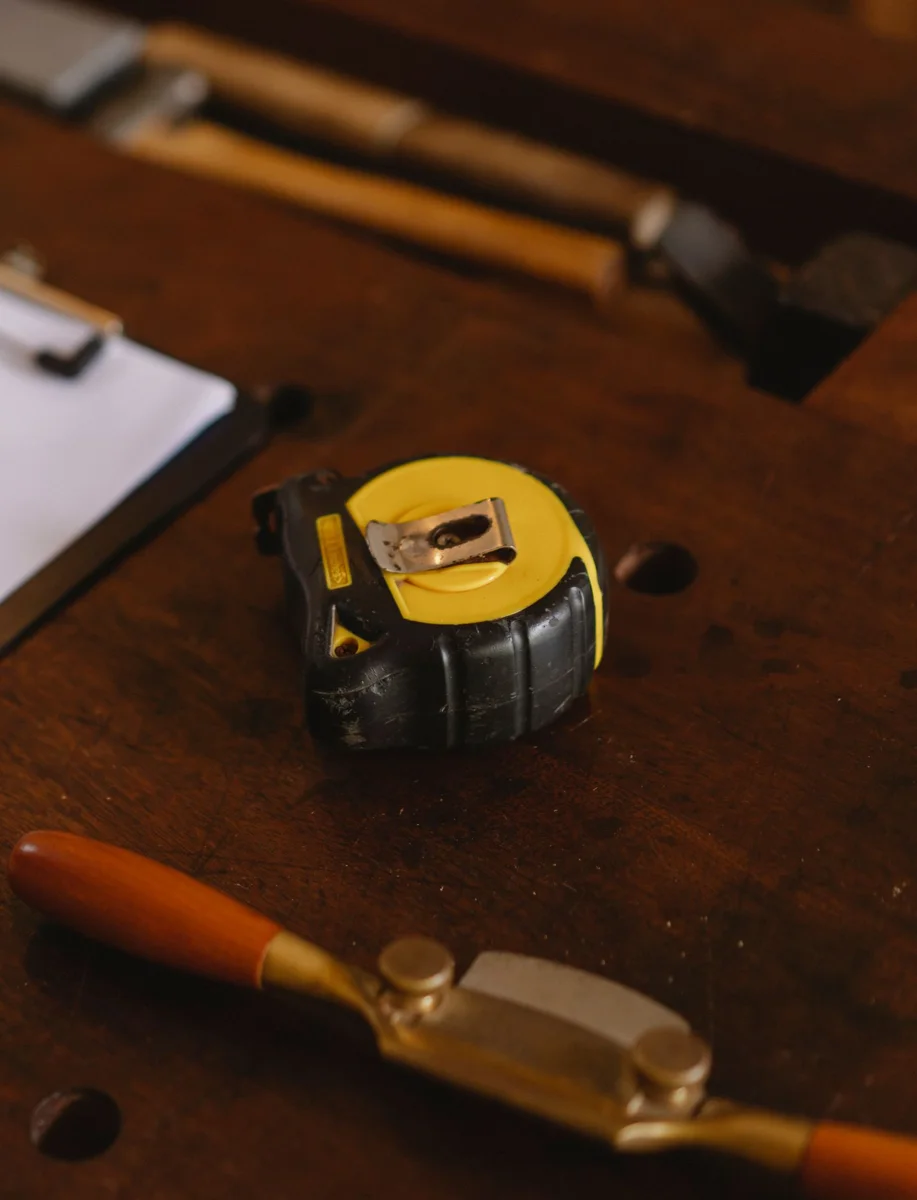 Measuring tape and clipboard on a wooden workbench