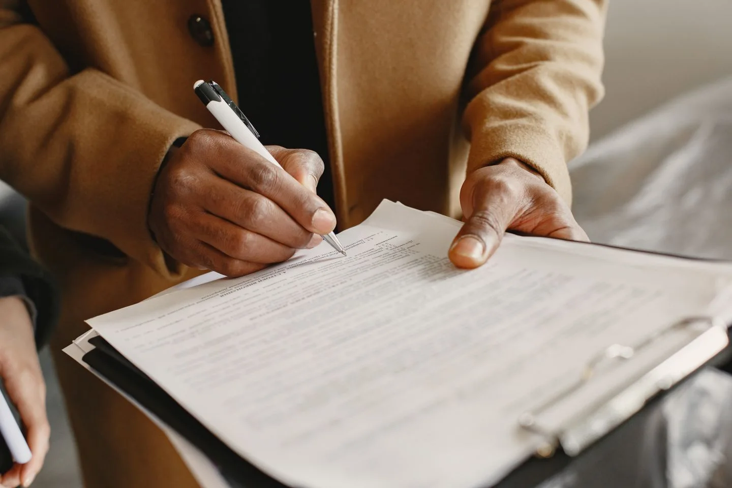Hand reviewing a paper document with a pen