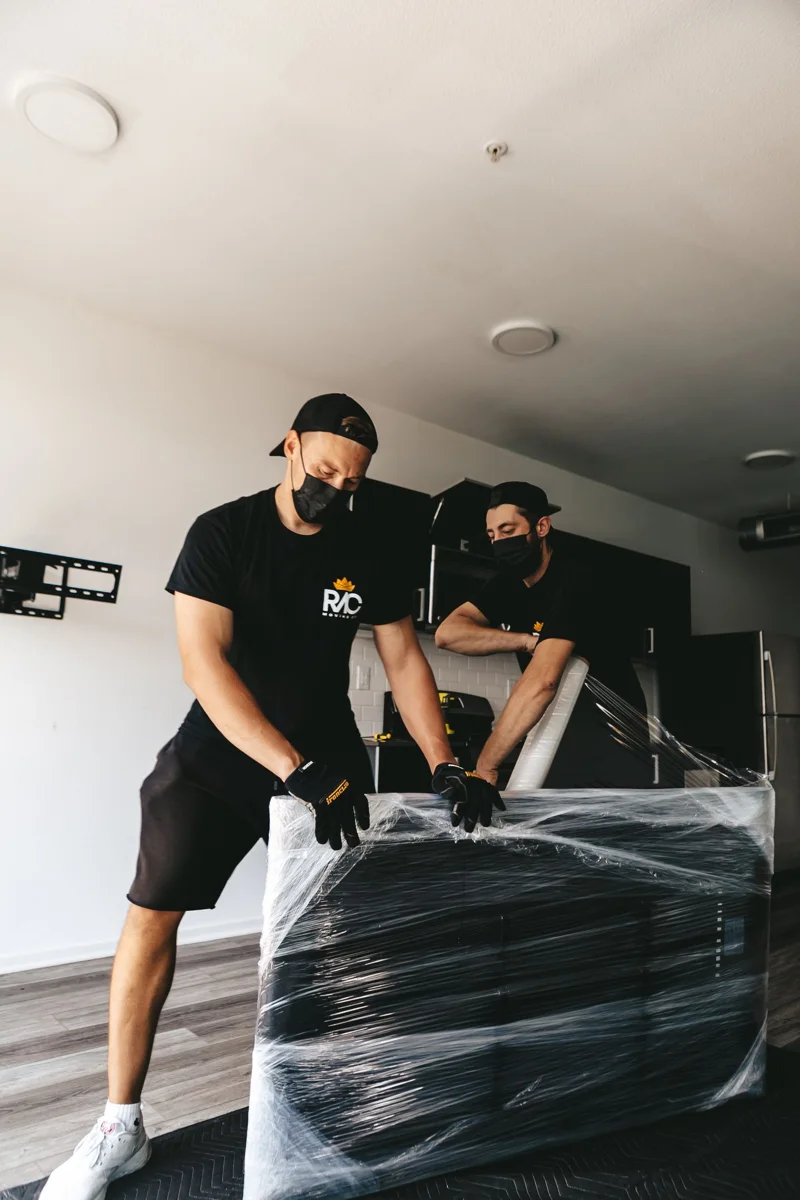 A wrapped household object is moved inside a room