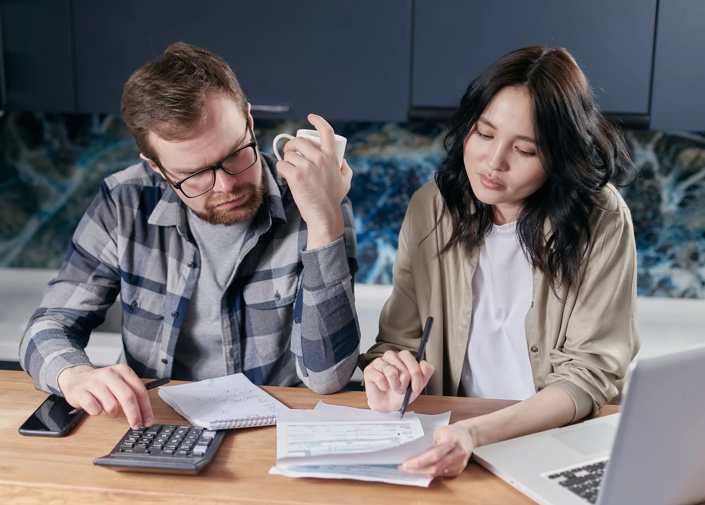 Two people review household bills with a calculator