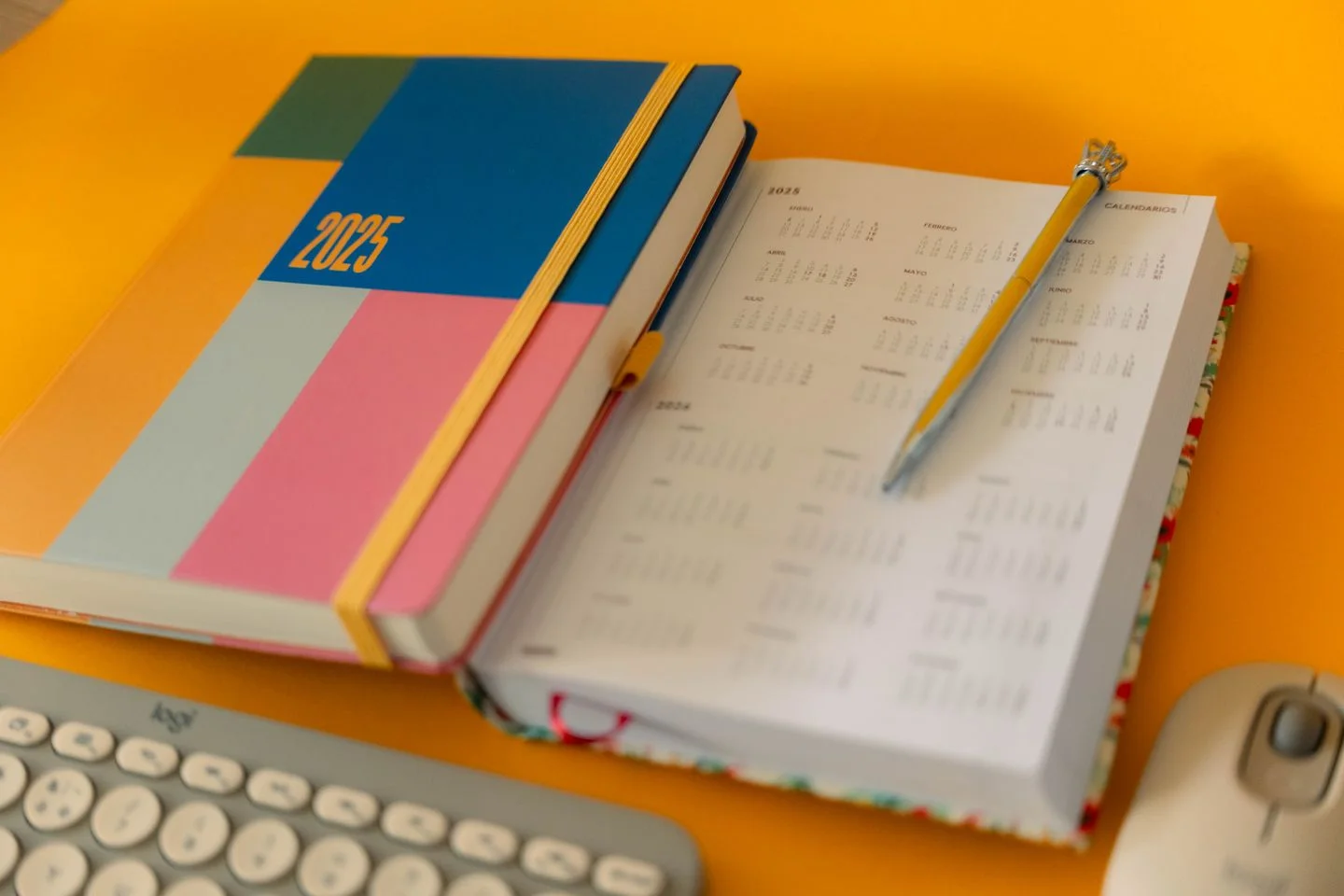 A planner and a separate calendar on a desk